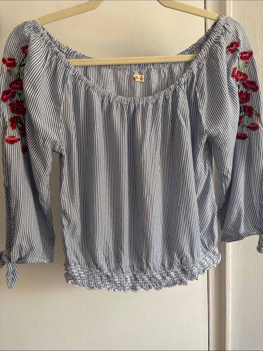 Hollister Blue and White Striped Off-Shoulder Top with Red Floral Embroidery.